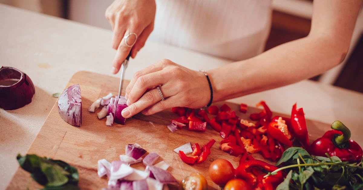Mujer cocinando un plato con verduras