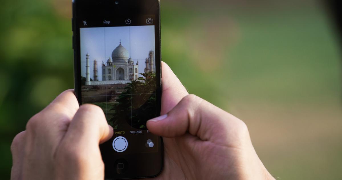 Imagen de archivo de una persona sacando una foto al Taj Mahal (India) con un móvil iPhone.