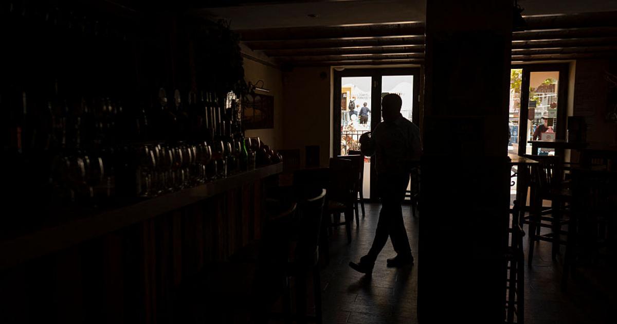 Un bar a oscuras, reflejo de millones de hogares y locales en España este lunes 28 de abril