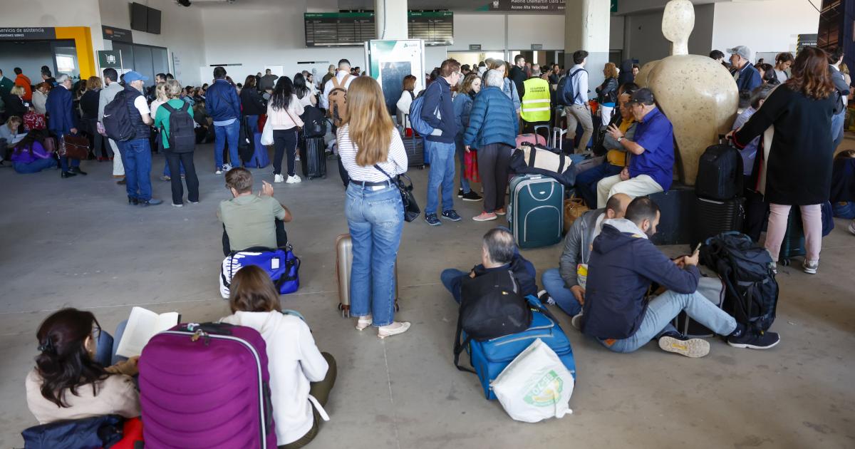 Usuarios aguardan en la estación de tren de Chamartín, en Madrid, tras registrarse un apagón a nivel peninsular este lunes.