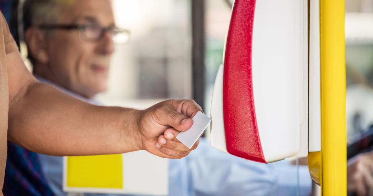 Una persona paga el billete de autobús.