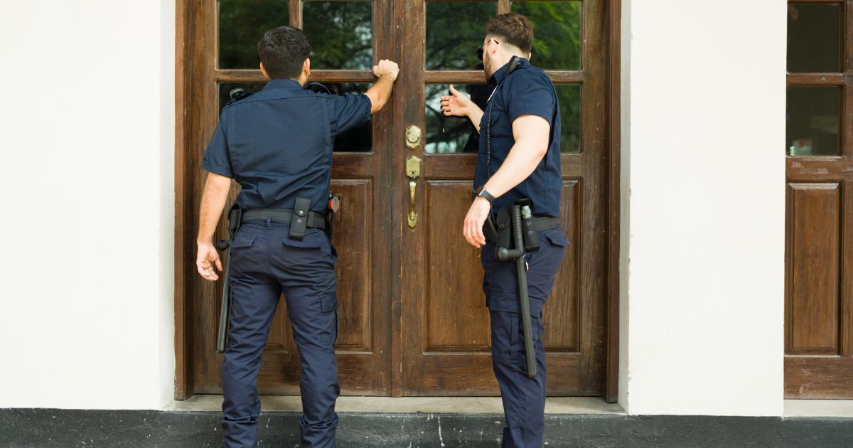 Imagen de dos agentes tocando a la puerta de una vivienda.