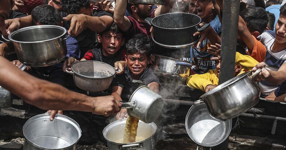Ciudadanos palestinos se agolpan en un punto de entrega de ayuda humanitaria en Gaza.