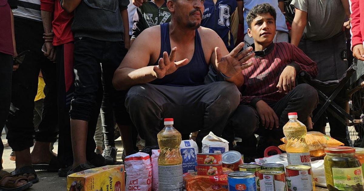 Un palestino muestra el kit de alimentación que ha recibido en Gaza.