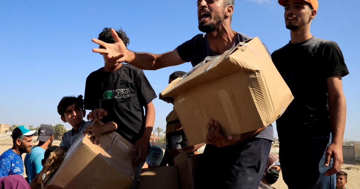Palestinos tratando de conseguir algo de la ínfima ayuda humanitaria que llega a repartirse en un punto de distribución, en el paso de Rafá.
