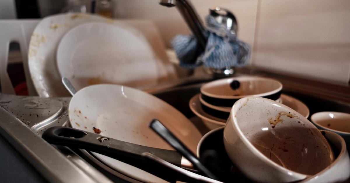 Loza acumulada en un fregadero esperando a que alguien la lave.
