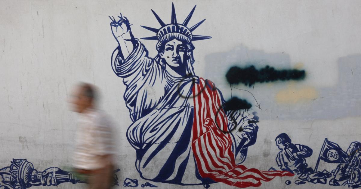 Un hombre pasa delante de un mural contra Estados Unidos en Teherán.