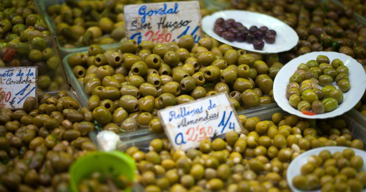 Un puesto en un mercado de Málaga con varios tipos de aceituna a la venta.