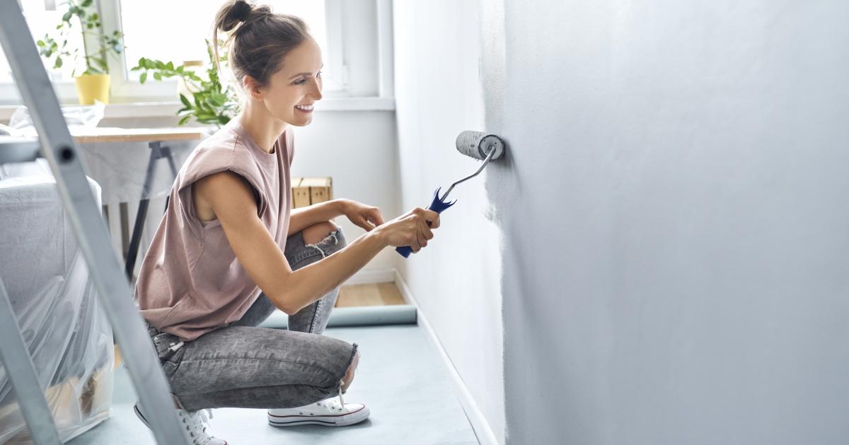 Una mujer pintando su casa.
