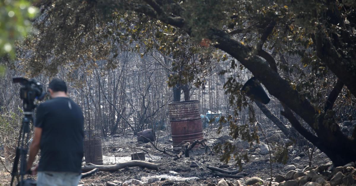 Un reportero toma imágenes tras el paso del incendio en Carucedo (León) este lunes 11 de agosto de 2025.