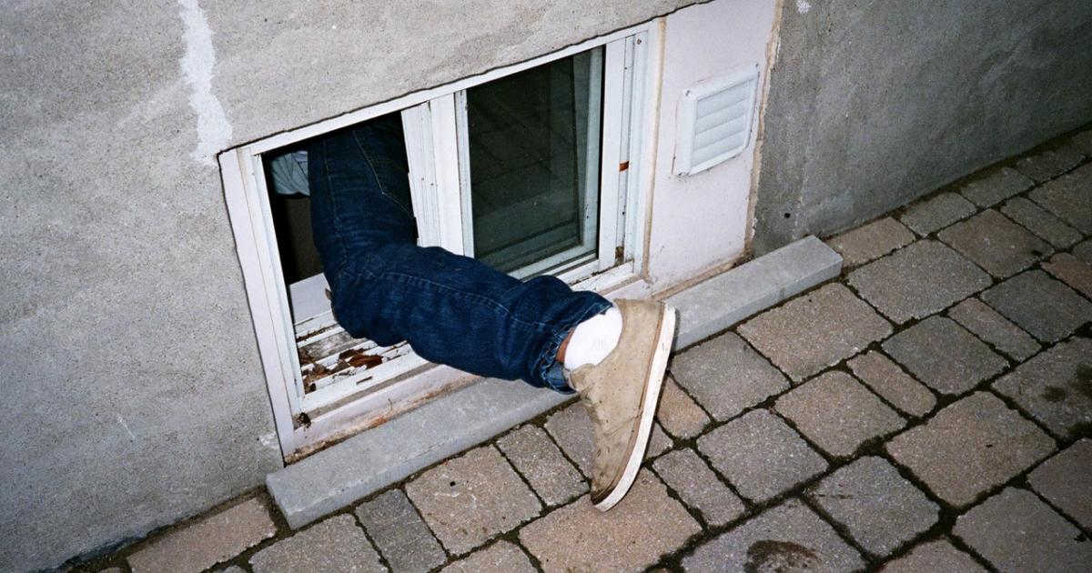 Un ladrón accede por una ventana baja en una imagen de archivo.