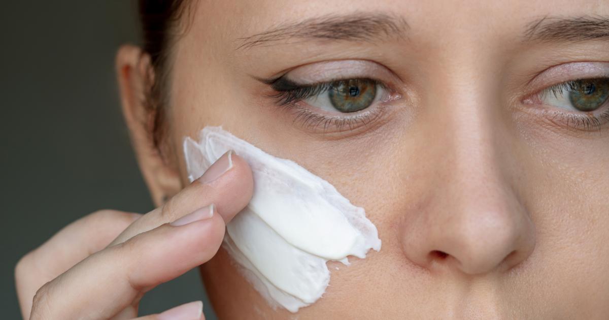 Imagen de archivo de una persona poniéndose crema en el rostro.