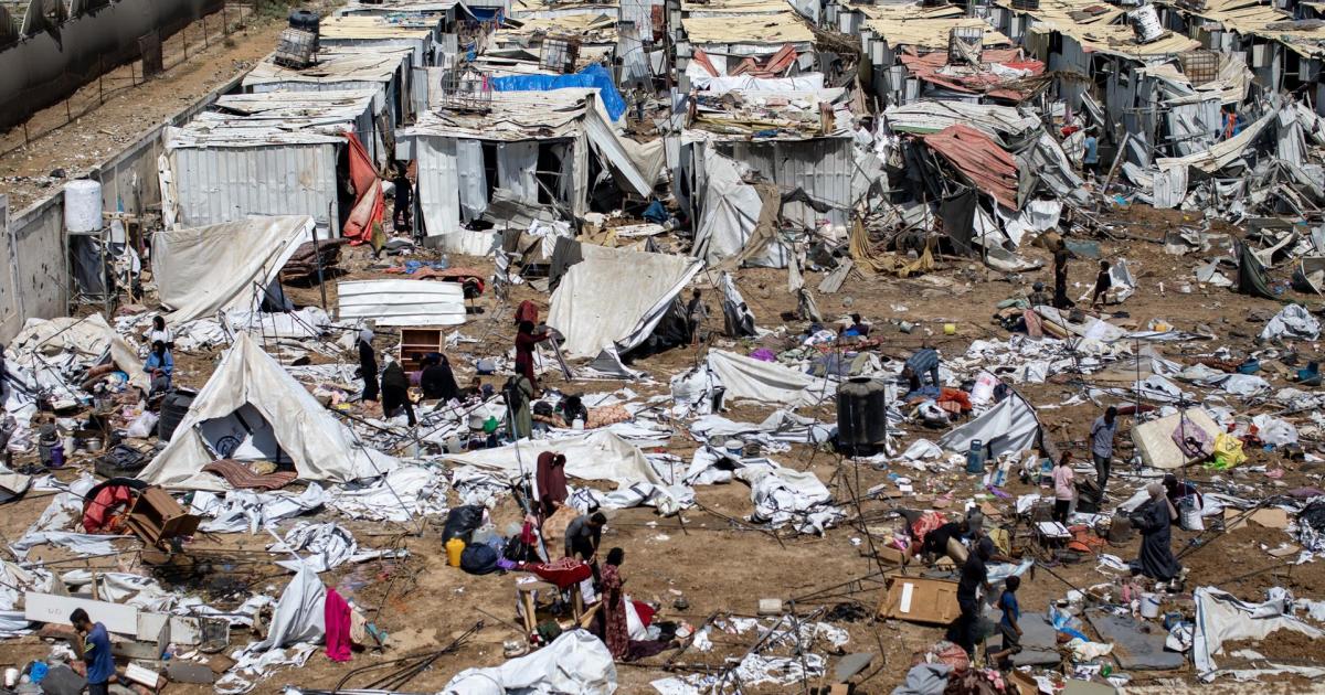 Palestinos desplazados inspeccionan las tiendas de campaña destruidas después de un ataque israelí en el campamento de Al-Manasrah, que albergaba a más de 200 familias en Deir al-Balah, en el centro de la Franja de Gaza, el 21 de agosto de 2025.