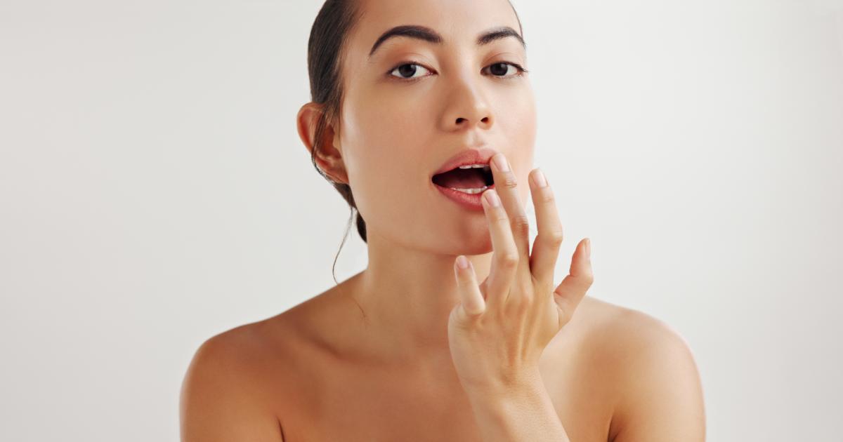 Mujer aplicándose bálsamo labial.