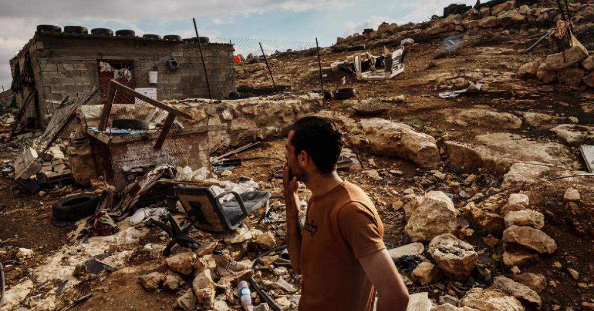 Un palestino inspecciona los daños causados por un ataque colono en su casa y sus tierras.