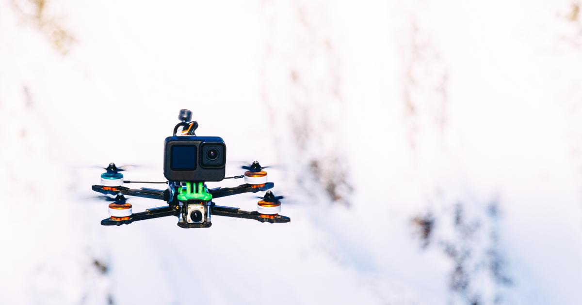 Dron con cámara de acción sobre un fondo de montañas nevadas.