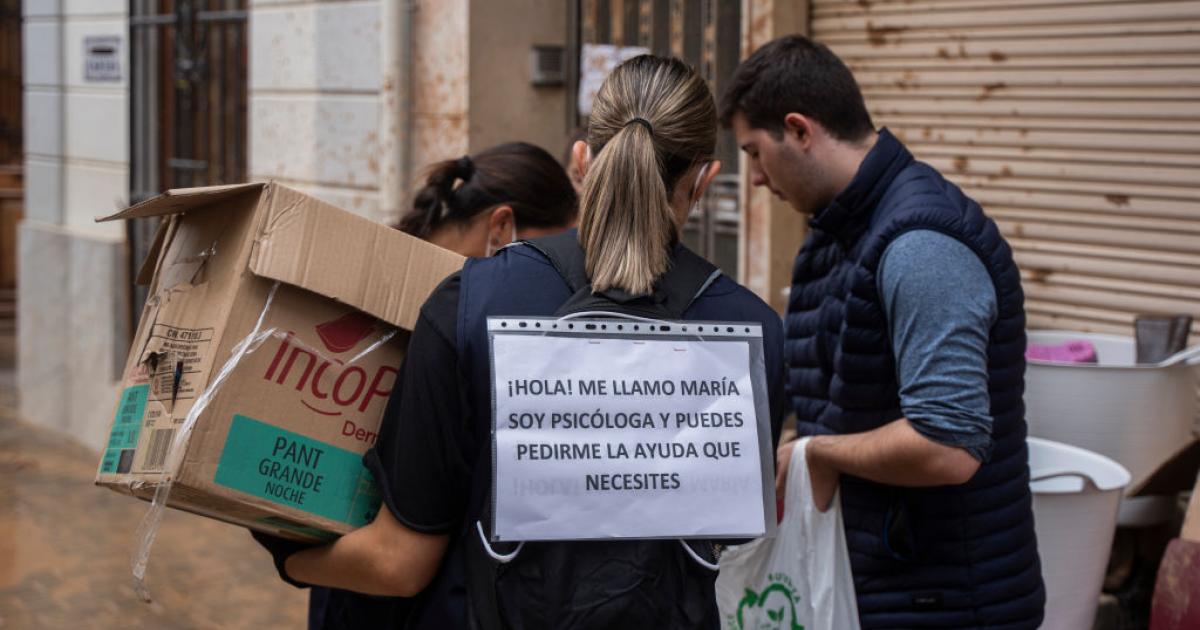 Una psicóloga se identifica con un cartel en las calles de Catarroja días después de la DANA