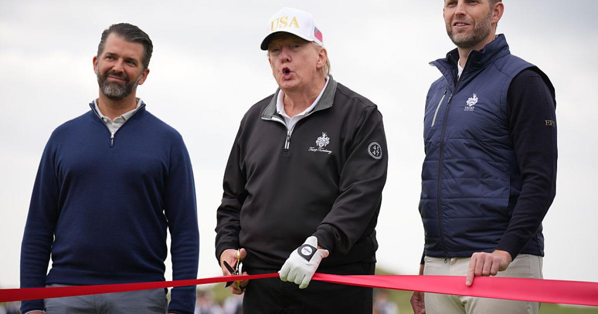 Donald Trump habla a sus hijos Donald Jr y a Eric Trump durante la inauguración de un nuevo campo de golf de la familia.