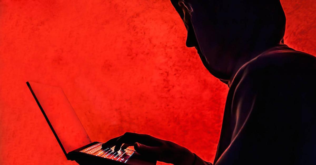 Silueta de un hacker sobre fondo rojo