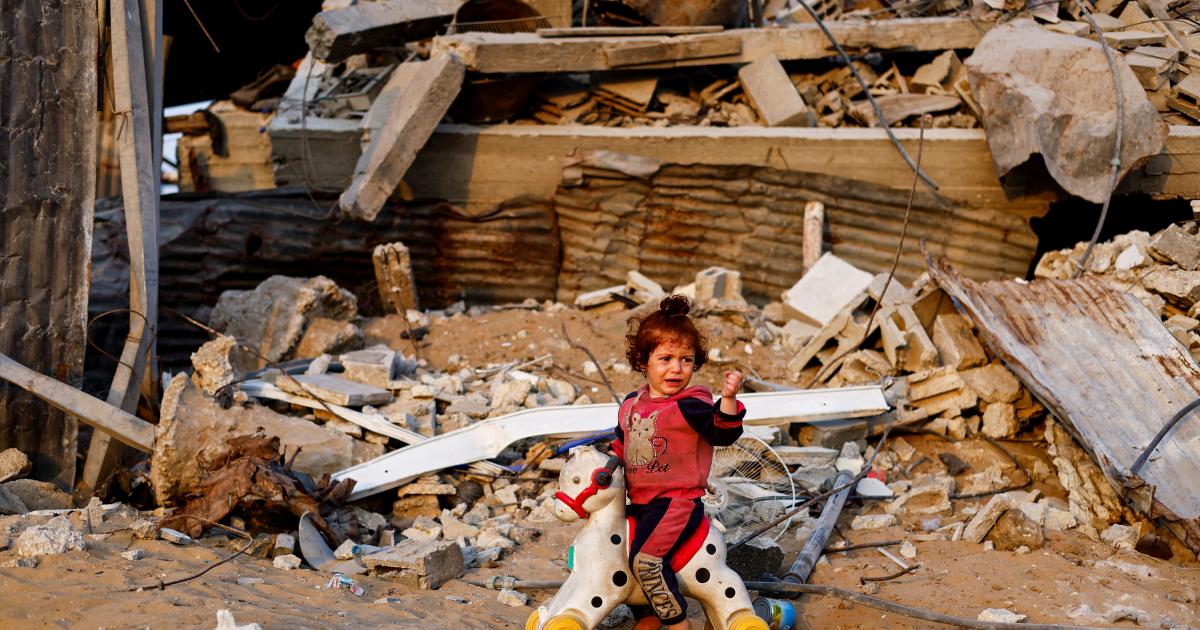 Una niña palestina montada en un caballo de plástico, entre los escombros de edificios destruidos por Israel en Jabalia, norte de Gaza, el 6 de noviembre de 2025.