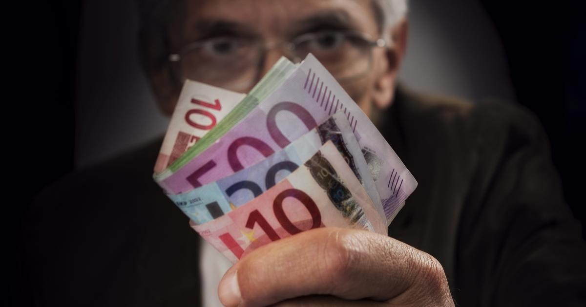 Un hombre enseñando un gran fajo de billetes.