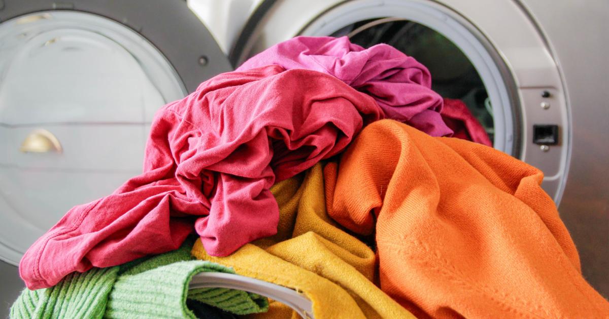 Montón de ropa delante de la lavadora.