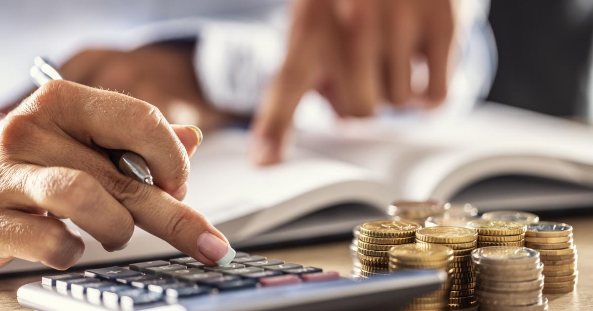 Man and woman hand consider on calculator expenses of family budget against home background. Lending purchase rental housing mortgage concept