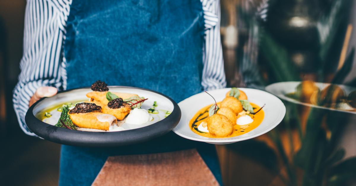 Una camarero sirviendo comida en una restaurante.