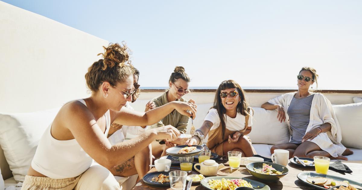 Un grupo de jóvenes de celebración alrededor de una mesa.