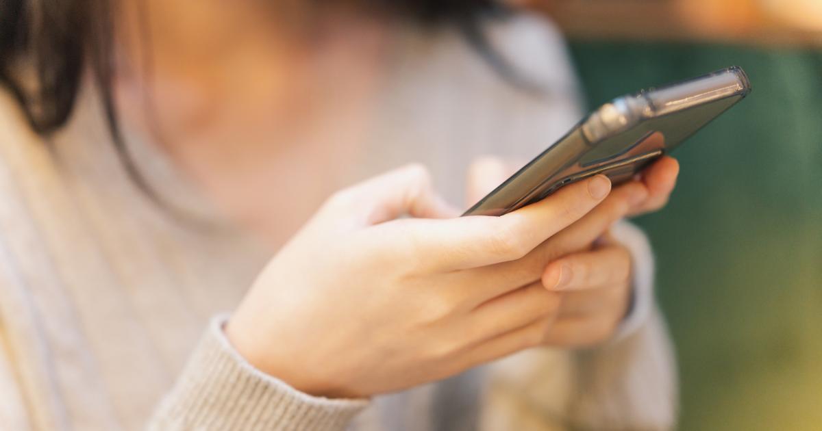 Una mujer usando la IA en su teléfono móvil.