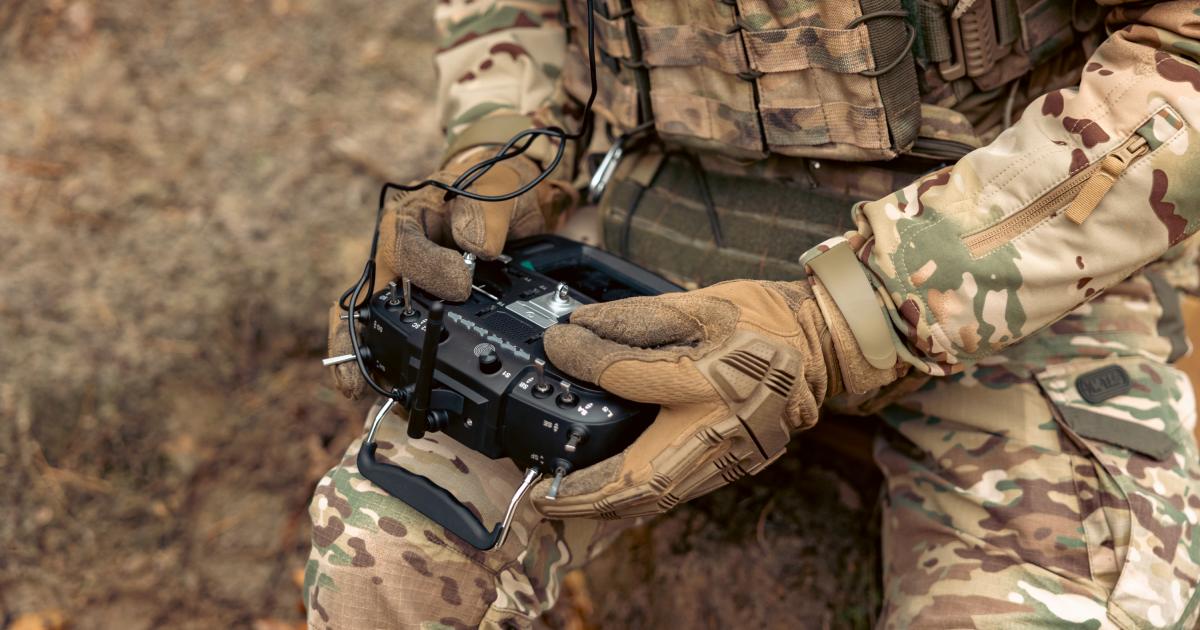 Un militar sentado, manipulando un control de dron.