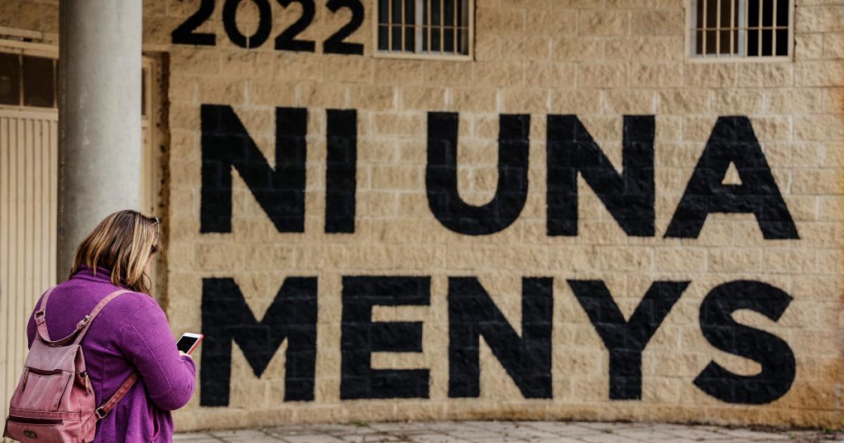 Una mujer pasa junto a un muro que dice "Ni una menos", en Valencia, en 2022.