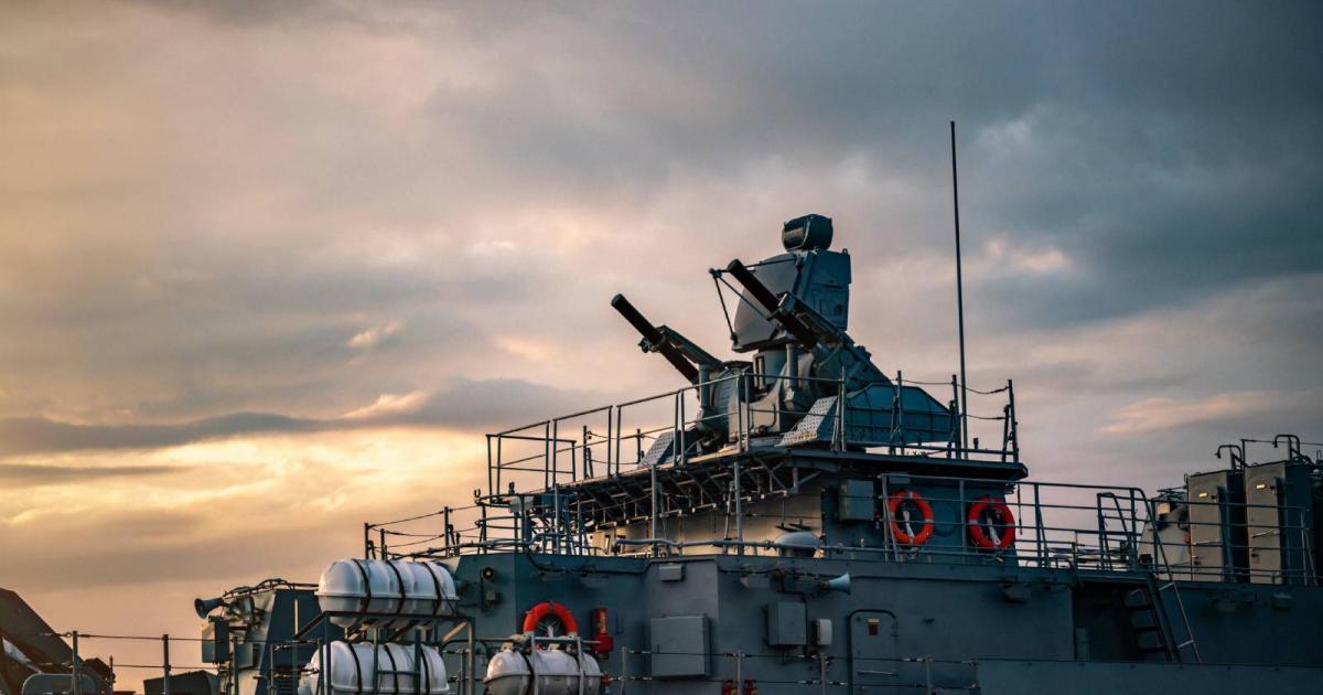 Torretas de portaaviones militares y armas en un buque de guerra al atardecer