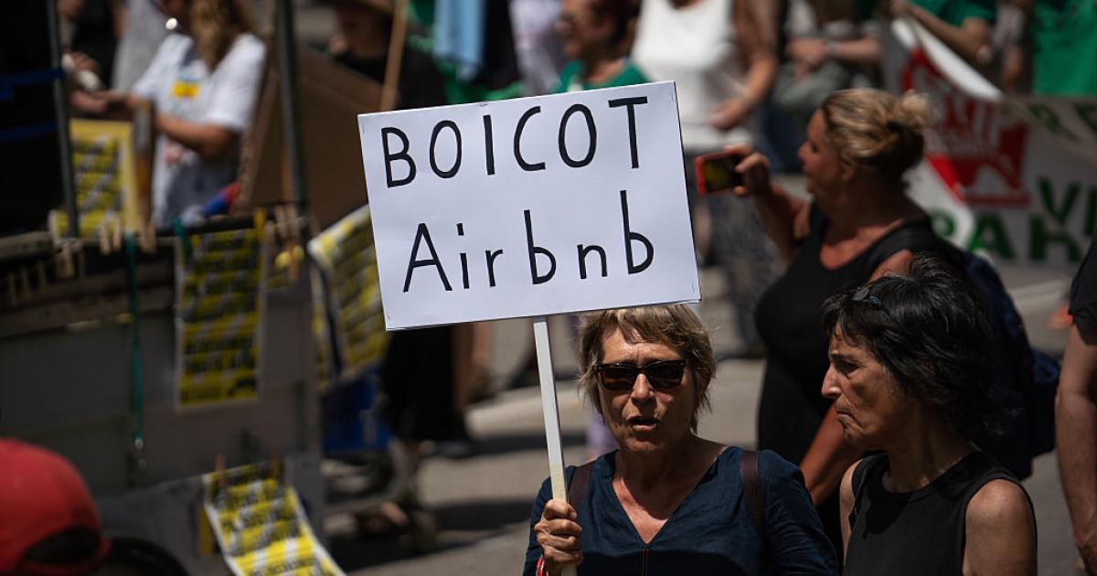 Un manifestante sostiene una pancarta que dice "Boicot Airbnb" durante una manifestación antiturismo en Barcelona, el 15 de junio de 2025.