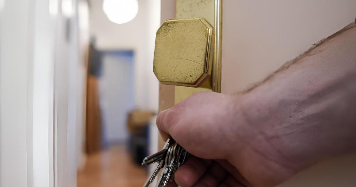 Un hombre abriendo la puerta de una vivienda.