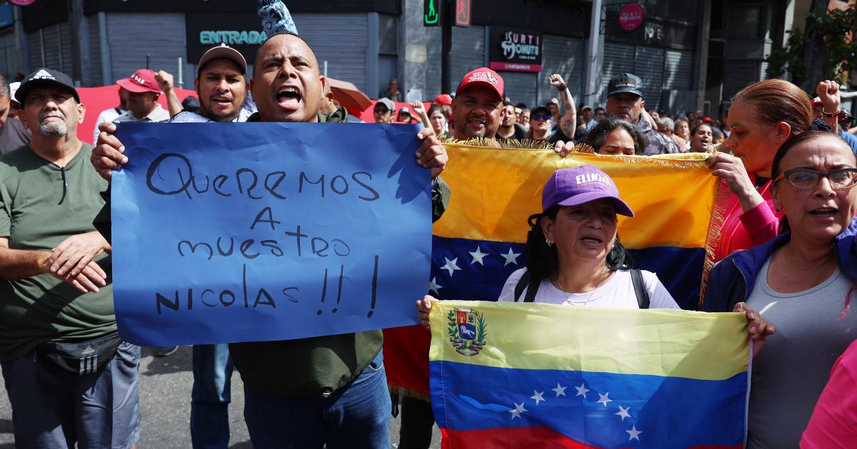 Simpatizantes del oficialismo sostienen carteles en inmediaciones del Palacio de Miraflores este sábado, en Caracas (Venezuela). Chavistas salieron a las calles del centro de Caracas para exigir que "devuelvan" al mandatario venezolano, Nicolás Maduro, luego de que el líder estadounidense, Donald Trump, anunciara la captura del gobernante suramericano en medio de un ataque con misiles durante la madrugada de hoy contra la capital venezolana y otras zonas del país.