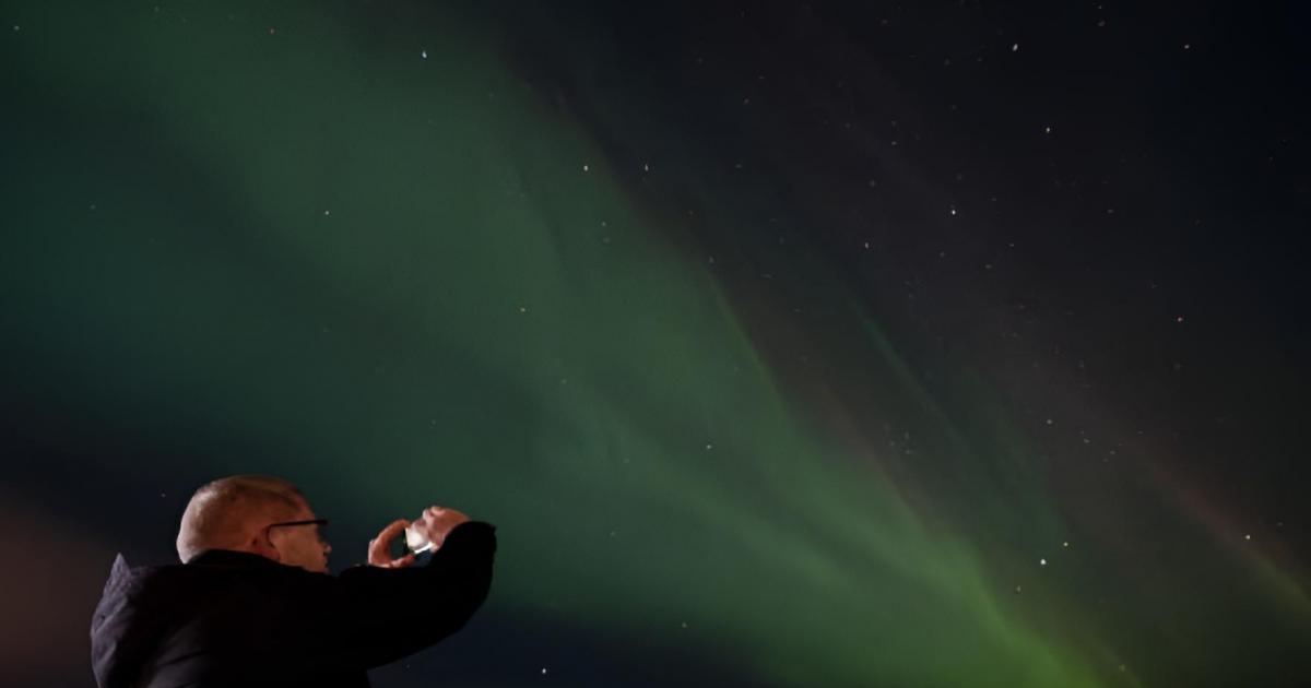 Una persona tomando fotografías de la aurora boreal en la ciudad de Hamar en Noruega.