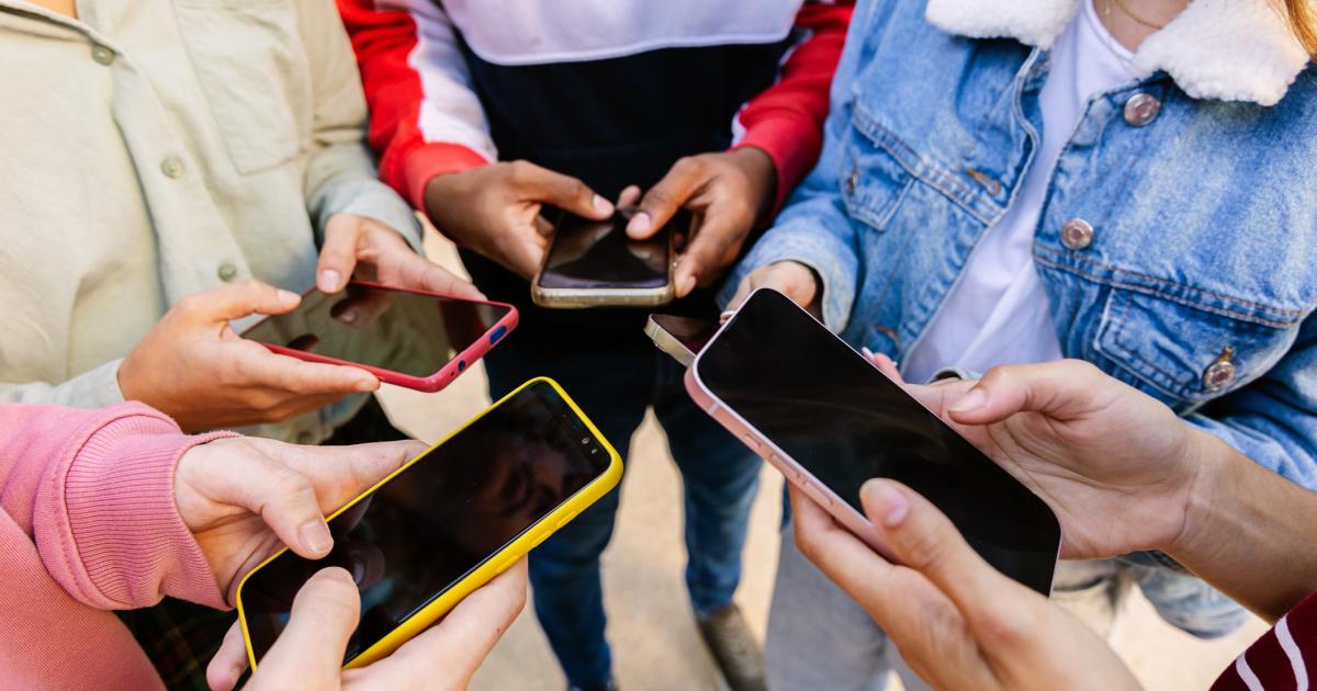 Un grupo de adolescentes, compartiendo contenido en sus móviles, en una imagen de archivo.