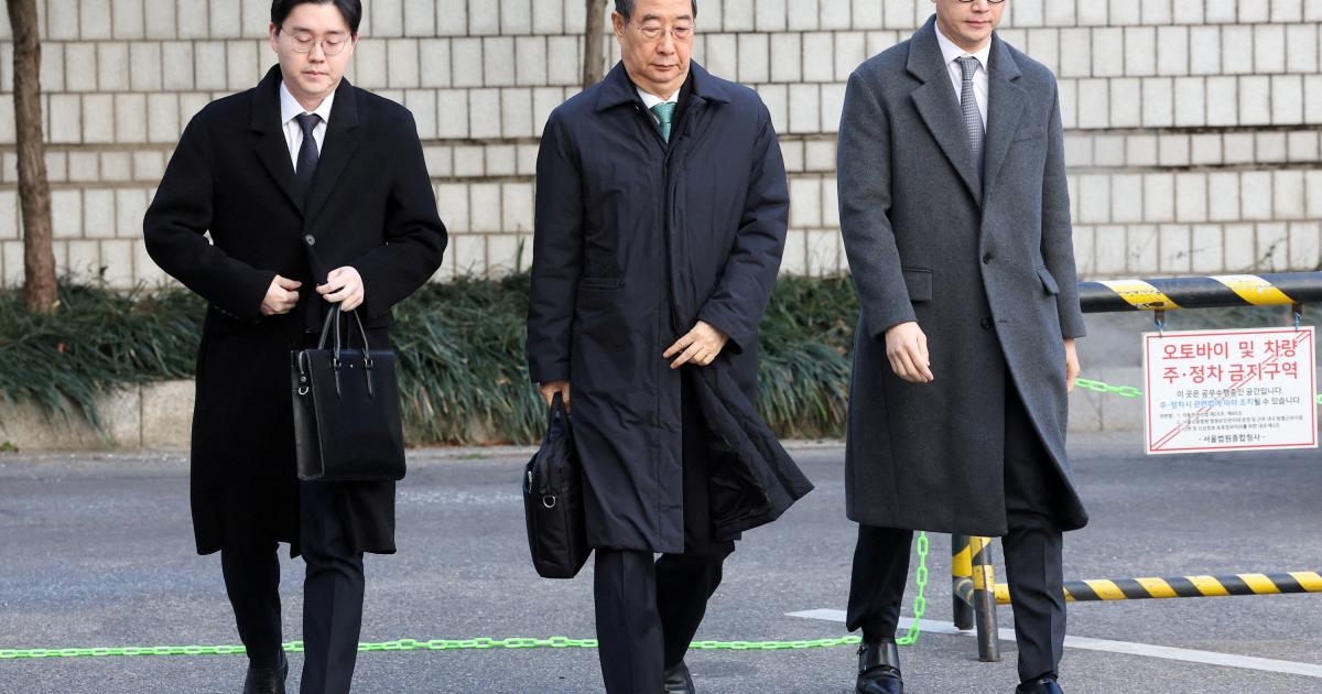 El ex primer ministro surcoreano Han Duck-soo, en el centro, de camino al juicio por el episodio de la fallida imposición de la ley marcial.