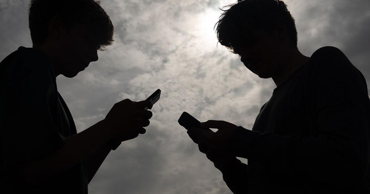 Adolescentes usando teléfonos móviles, imagen relacionada con el debate en Francia sobre la prohibición de redes sociales a menores de 15 años.