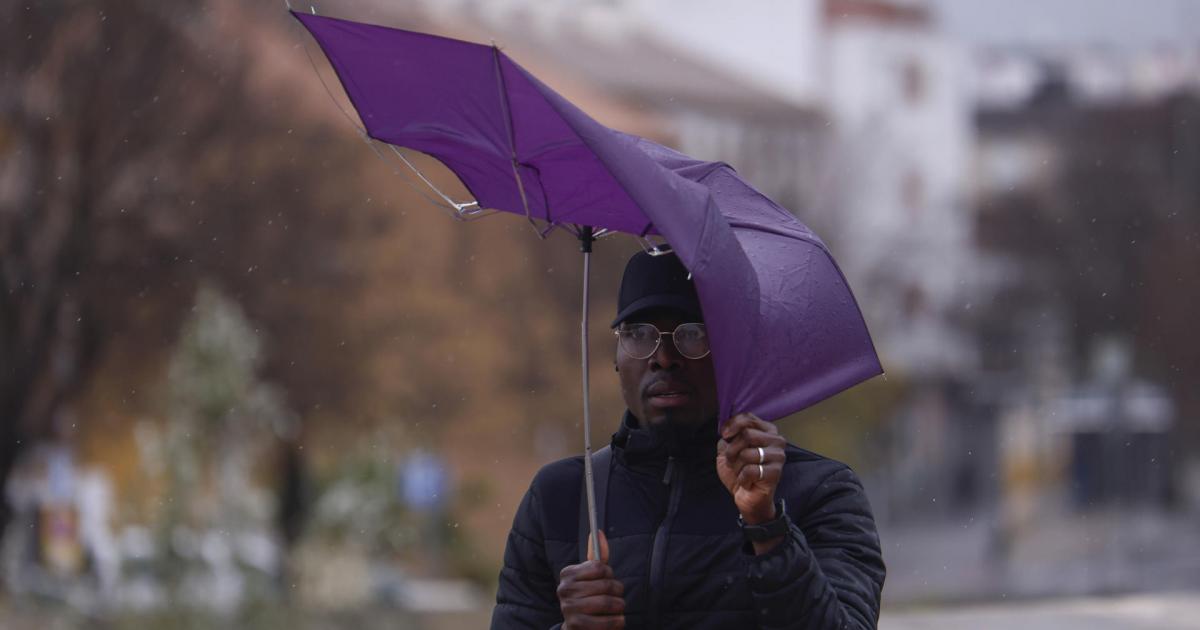 Un hombre intenta protegerse de la lluvia y el viento en Córdoba.