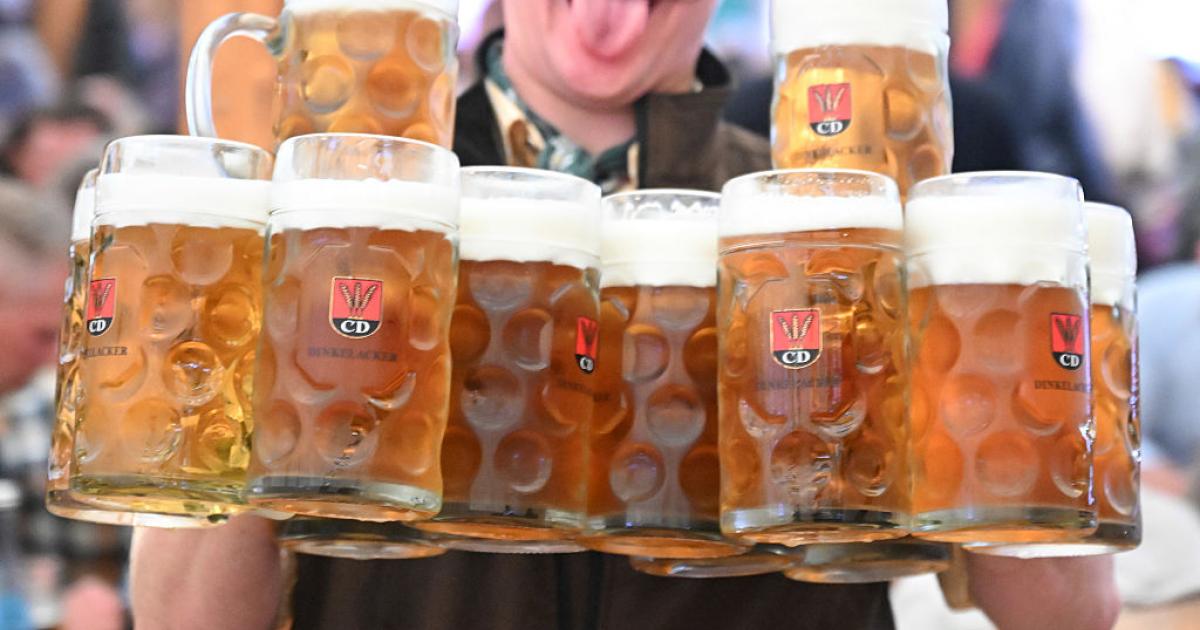 Camarero sostiene varias jarras de cerveza durante una celebración popular en Alemania