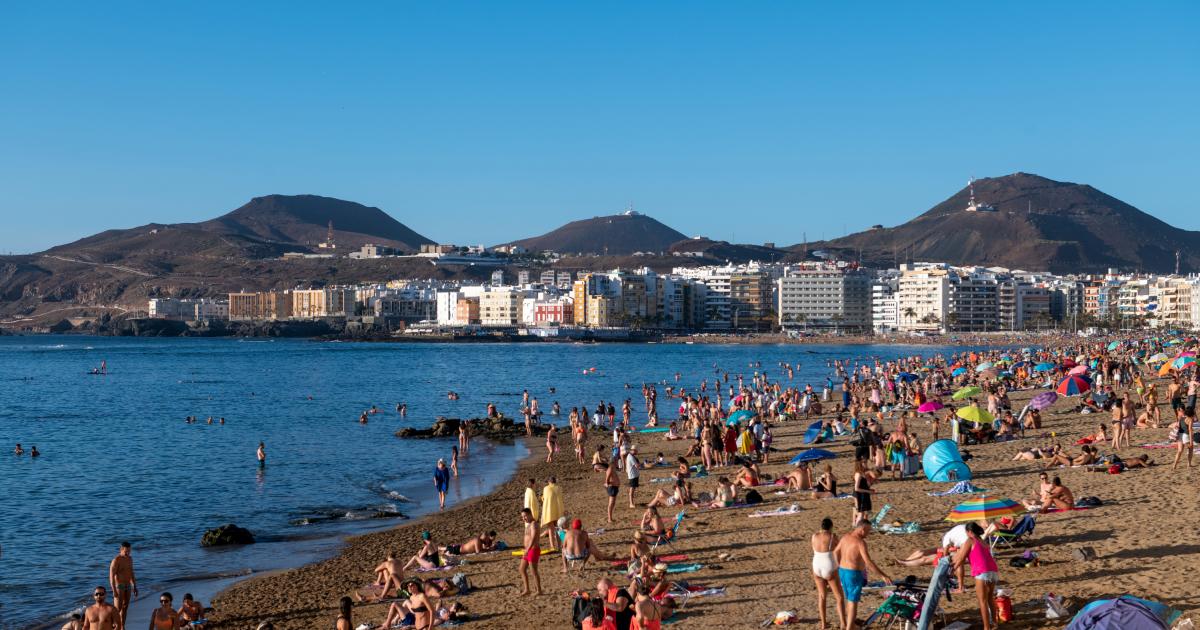 Un grupo de personas en la playa en una imagen de archivo