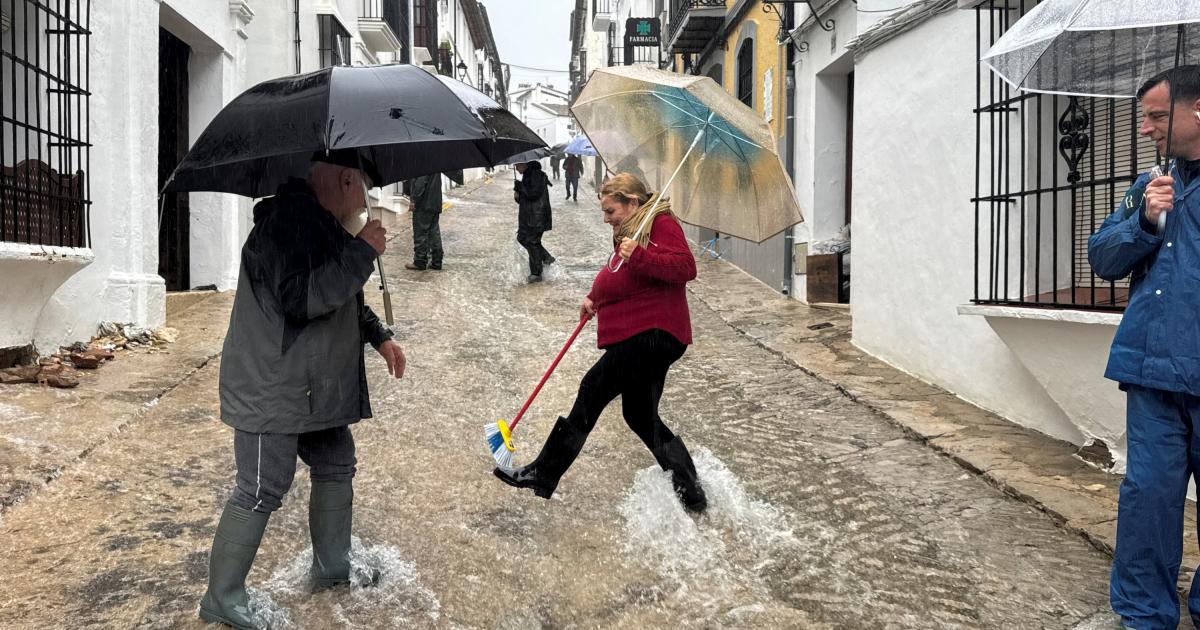 Un grupo de vecinos caminan por una calle inundada debido a las fuertes lluvias en Grazalema (Cádiz), el 5 de febrero de 2026.