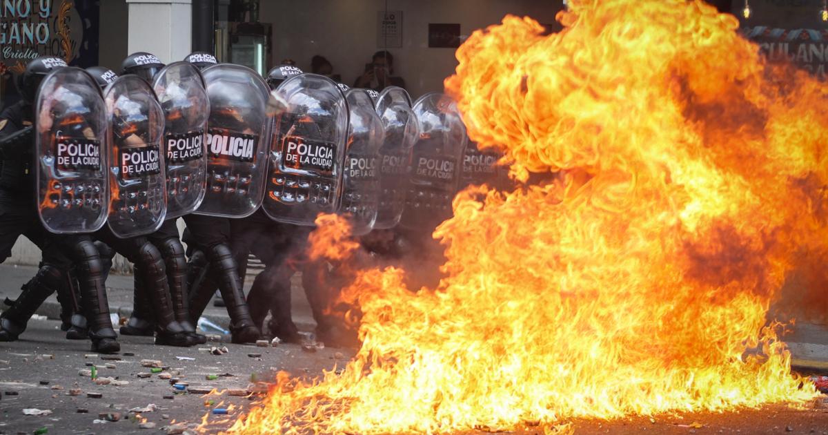Integrantes de la Policía de Argentina se cubren durante un enfrentamiento con manifestantes contra la reforma laboral de Javier Milei, el 11 de febrero de 2026, en Buenos Aires.