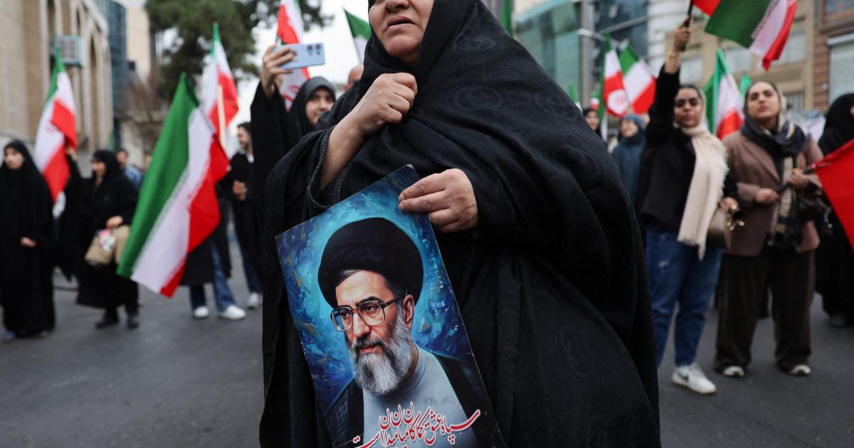 Una mujer sostiene una imagen del líder supremo de Irán, el ayatolá Ali Jamenei, el 28 de febrero de 2026, en las calles de Teherán, la capital.