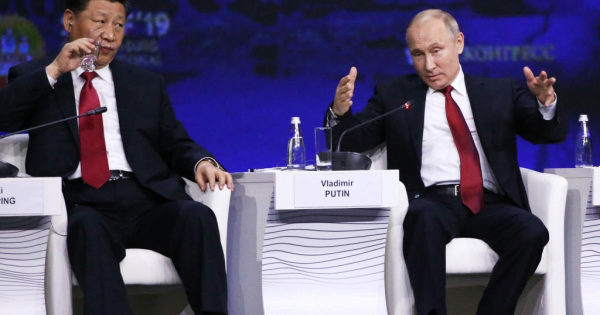 El presidente chino, Xi Jinping, bebe agua mientras observa a un gesticulante presidente ruso, Vladimir Putin, en el Foro Económico Internacional de San Petersburgo, el 6 de junio de 2019.