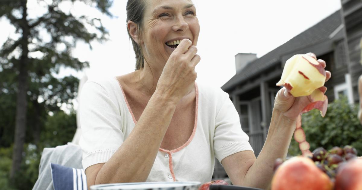 Imagen de archivo de una mujer comiendo fruta.