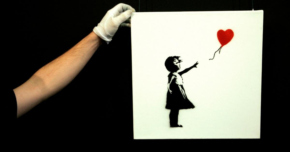 FILE PHOTO: A gallery technician adjusts Banksy's artwork "Balloon Girl" at Sotheby's auction house at Olympia in London, February 2, 2007.  REUTERS / Luke MacGregor
