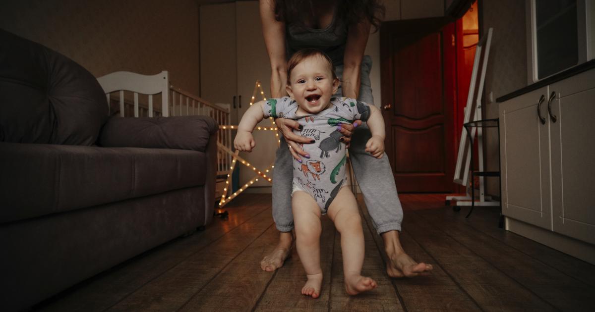 Un bebé y su madre andan descalzos por casa